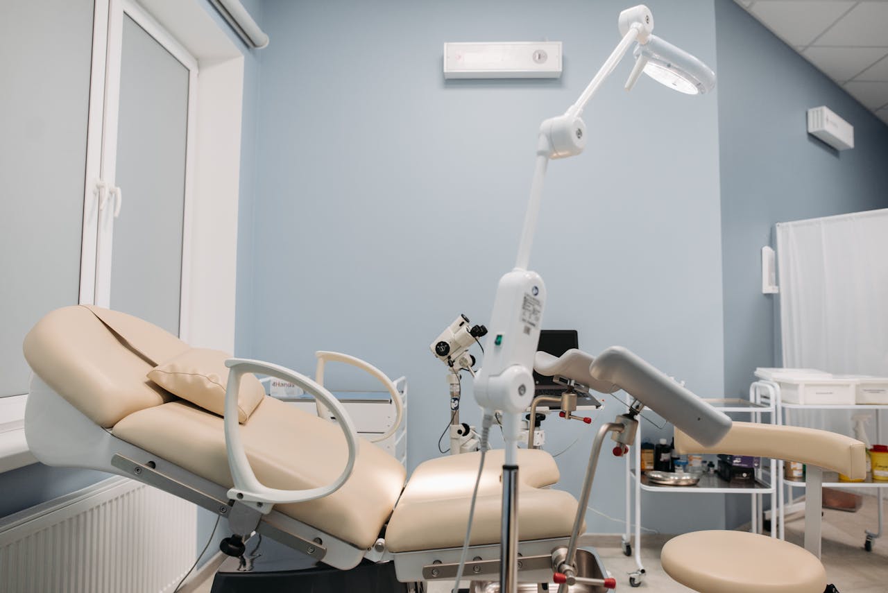Bright and clean interior of a modern clinic with medical equipment and examination table.